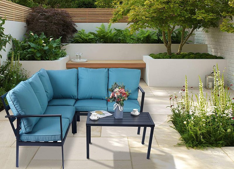 A vibrant outdoor seating set featuring a striking blue-cushioned sectional sofa paired with a sleek black coffee table. The setup is placed on a light-colored tiled patio, surrounded by lush greenery and elegant garden elements, creating an inviting and stylish outdoor lounge area.
Stylish Blue Outdoor Sofa Set for Patio Lounging.
outdoor sofa set, blue cushions, black coffee table, patio furniture, garden seating, outdoor lounge area