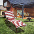 A foldable lounge chair with vibrant red and white striped cushions is placed on a well - maintained lawn in a backyard setting. The chair features a convenient side cup - holder, perfect for relaxing outdoors. The background shows a cozy house with outdoor furniture, enhancing the inviting atmosphere. Red and White Striped Foldable Lounge Chair for Outdoor Relaxation. foldable lounge chair, red and white striped cushions, outdoor relaxation, side cup - holder, backyard furniture.