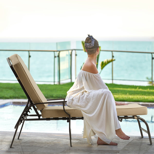 Luxurious Outdoor Lounge Chair by the Pool
alt text：A woman in a white dress sits on a stylish outdoor lounge chair with beige cushions, set by a pool with a scenic ocean view in the background. Keywords: outdoor lounge chair, poolside, ocean view
