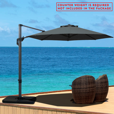 A gray cantilever patio umbrella set up on a wooden deck overlooking the ocean. Note: Counter weight is required and not included in the package.
Outdoor offset umbrella providing shade near wicker chairs by the seaside. Counter weight needed, not part of the package. Seaside Cantilever Umbrella: Counter Weight Not Included. Ocean - View Patio Umbrella: Counter Weight Required. cantilever umbrella, patio umbrella, outdoor umbrella, seaside umbrella, counter weight, wicker chairs, ocean - view
