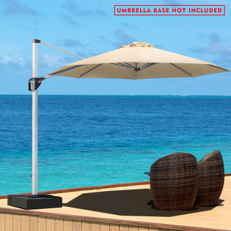 A beige - colored cantilever patio umbrella stands on a wooden deck overlooking a stunning blue ocean. The umbrella is positioned to provide shade over a pair of wicker chairs. A red notice at the top states "UMBRELLA BASE NOT INCLUDED". The serene seascape in the background enhances the relaxing outdoor setting.Beige Cantilever Patio Umbrella by the Sea: Base Not Included.cantilever patio umbrella, offset umbrella, beige umbrella, umbrella base not included, seaside patio, wicker chairs.