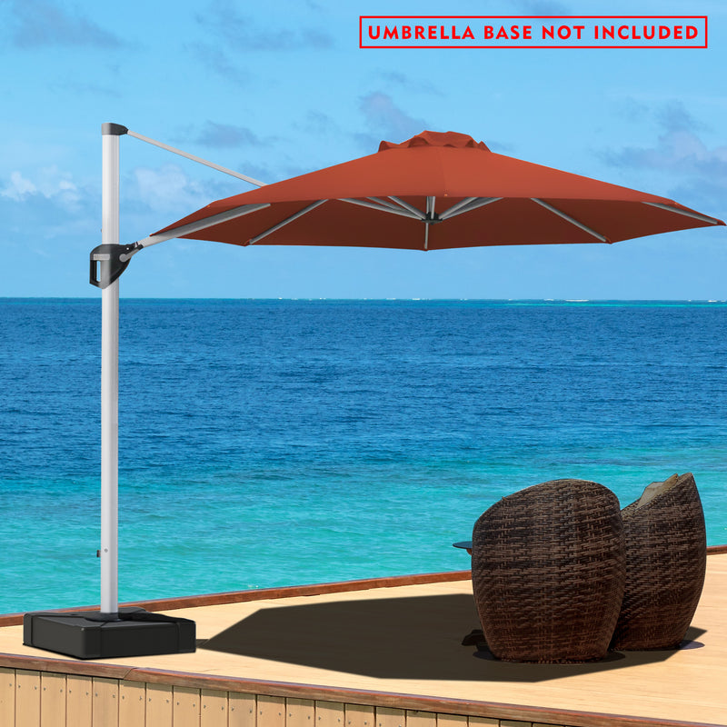 A red - colored cantilever patio umbrella stands on a wooden deck overlooking a stunning blue ocean. The umbrella is positioned to provide shade over a pair of wicker chairs. A red notice at the top states "UMBRELLA BASE NOT INCLUDED". The serene seascape in the background enhances the relaxing outdoor setting.Red Cantilever Patio Umbrella by the Sea: Base Not Included.cantilever patio umbrella, offset umbrella, red umbrella, umbrella base not included, seaside patio, wicker chairs.
