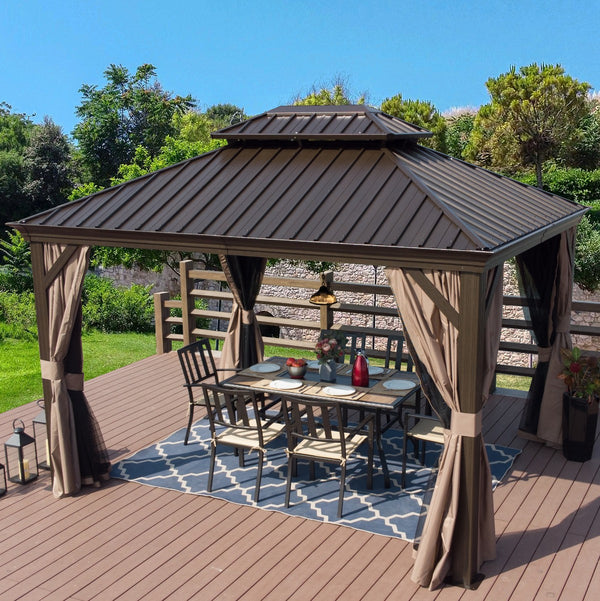 A stylish outdoor gazebo with a dark brown metal roof and wooden - look frame is set on a wooden deck. The gazebo features beige curtains tied back, and underneath it is an outdoor dining area with a metal table, chairs, a decorative rug, and table settings including plates, a vase with flowers, and a red bottle. The background includes greenery and a stone wall, creating a serene outdoor space. Elegant Outdoor Gazebo for Relaxing and Dining. outdoor gazebo, metal roof, wooden frame, beige curtains, outdoor