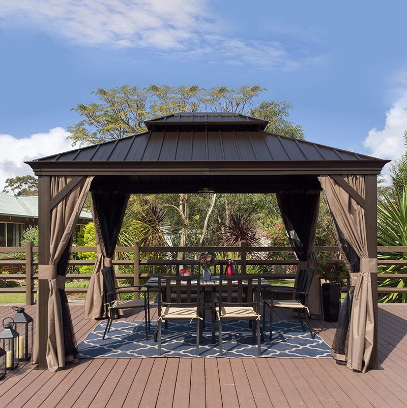A charming outdoor gazebo with a dark brown metal roof and wooden - toned frame stands on a wooden deck. Beige curtains are tied back around the gazebo, which houses an outdoor dining setup with a table, chairs, and a decorative blue - and - white rug. The background features lush greenery and a clear blue sky with scattered clouds. Inviting Outdoor Gazebo for Relaxation and Dining. outdoor gazebo, metal roof, wooden frame, beige curtains, outdoor dining area.