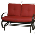 A glider chair with red cushions, featuring dimensions of 47 inches in width, 33.5 inches in height, and a seat cushion thickness of 6 inches. The chair has a sturdy metal frame with curved arm-rests, and a height of 29.1 inches from the ground to the bottom of the frame. red-cushioned glider chair, metal-framed glider, cushioned seating, chair dimensions.